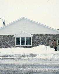 Man Shoveling Snow at Main St. Side of Library