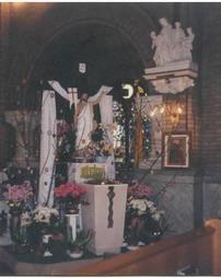Christ Statue, with flowers in front of a Cross as Sts. Casimir and Emerich Church