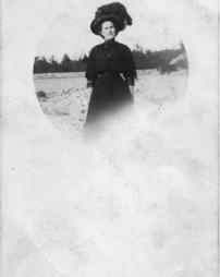 Lady standing outside in a plumed hat