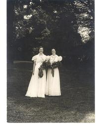 Two girls under trees at graduation, 1938