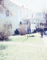 People Walking in Yard of Maple Manor