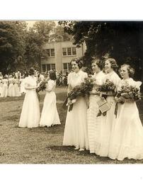Four girls pose with roses and diplomas after graduation, 1938