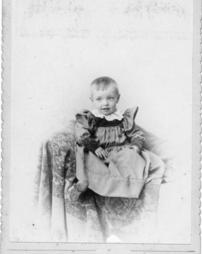 Young child sitting on fancy throw