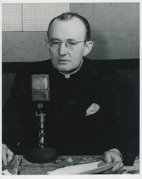 Monsignor Charles Owen Rice Seated at a Microphone Photograph