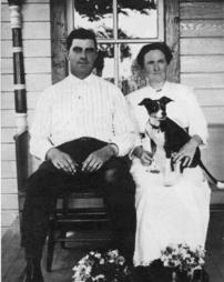 Man and woman sit with dog