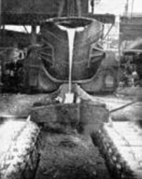 Front view of ladle emptying molten steelinto moulds