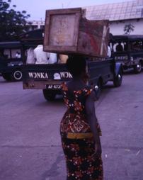 Woman walks with crate on her head
