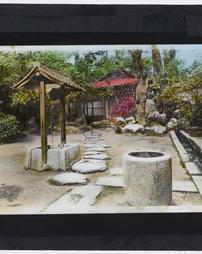 Japan. [Japanese garden with wellhead and water basin]