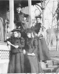 Four people in front of J.M. Olinger's porch