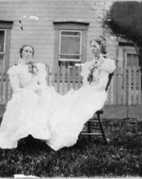 Two women sitting in chairs in the yard