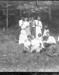 Women and children in front of the woods