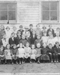 Elementary class in front of school windows