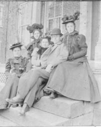 Four women and a man sitting on J.M. Olinger's porch