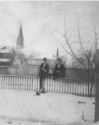 Two men on a fence near H.M. Cook's Optical Parlor