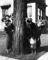 Students Peek From Behind a Tree