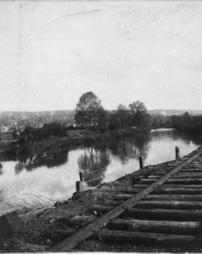 Railroad tracks beside a reflective river