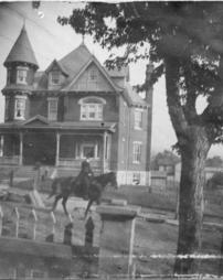 Horse and rider in front of Rowe House