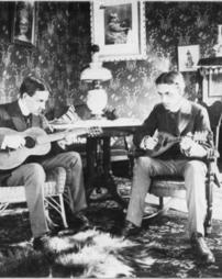 Charlie Cook playing a mandolin and a friend with a guitar