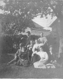 Group of people under a tree in J.M. Olinger's yard