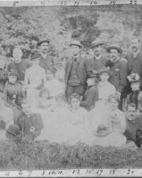 Group of men and women sitting in the grass