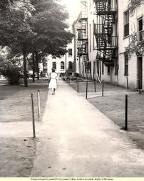 Female Student Walking Behind Old Main