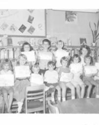 Children holding papers at a library
